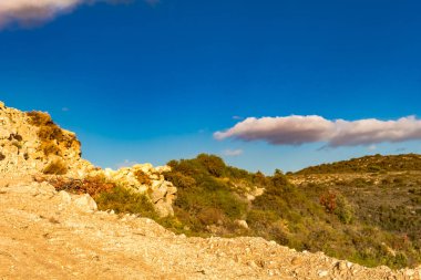 Kıbrıs Rum Kesimi 'nin berrak gökyüzü, az bulut ve sınırlı bitki örtüsü ile manzaralı sakin bir fotoğraf, adanın doğal güzelliğini gösteriyor