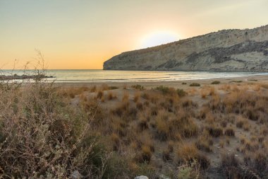Kıbrıs 'taki Zapallo Körfezi Sahili' nde büyüleyici bir gün batımı, alacakaranlık batışı, dağın arkasında güneş batışı, çarpıcı bir akşam manzarası.