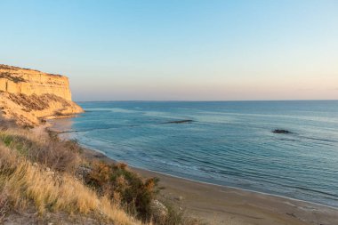 Kıbrıs kıyı şeridindeki bir uçurumdan deniz manzarası büyüleyici. Akdeniz 'in sakin güzelliğini gün batımında gösteriyor.