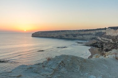 Kıbrıs 'taki Zapallo Körfezi Sahili' nde büyüleyici bir gün batımı, alacakaranlık batışı, dağın arkasında güneş batışı, çarpıcı bir akşam manzarası.