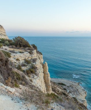 Kıbrıs kıyı şeridindeki bir uçurumdan deniz manzarası büyüleyici. Akdeniz 'in sakin güzelliğini gün batımında gösteriyor.