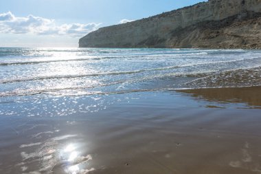 Kıbrıs 'ta bir sahilde denizin yüzeyine yansıyan güneş ışınlarının büyüleyici güzelliğini yakalayın. Suyun kenarında pırıl pırıl ve büyülü bir an yaratın.
