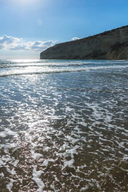 Kıbrıs 'ta bir sahilde denizin yüzeyine yansıyan güneş ışınlarının büyüleyici güzelliğini yakalayın. Suyun kenarında pırıl pırıl ve büyülü bir an yaratın.