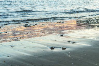 Kıbrıs 'ta bir sahilde denizin yüzeyine yansıyan güneş ışınlarının büyüleyici güzelliğini yakalayın. Suyun kenarında pırıl pırıl ve büyülü bir an yaratın.