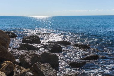 Kıbrıs 'taki Zapallo Körfezi Sahili' nin güzelliğini yaşayın kumlu kıyıları, denize dağılmış kayalar, güneşli bir günün sıcacık kucağında beyaz bir uçurum.
