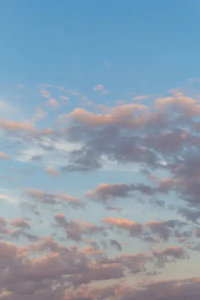 Dağların üzerindeki akşam güneşinin sakin güzelliğine tanık olun. Yumuşak bulutlarla bezenmiş ve batan güneşin yumuşak parıltısıyla yıkanmış. Huzurlu ve huzurlu bir atmosfer yaratıyor.