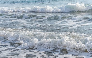 Kıbrıs 'ın kumlu sahillerinde dalgalar, güzel yaz deniz manzarası, deniz köpüğü ve kaya.