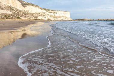 Kıbrıs 'ın kumlu sahillerinde dalgalar, güzel yaz deniz manzarası, deniz köpüğü ve kaya.