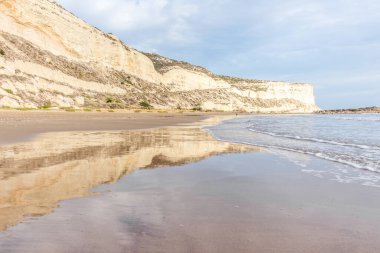 Kıbrıs 'ın kumlu sahillerinde dalgalar, güzel yaz deniz manzarası, deniz köpüğü ve kaya.