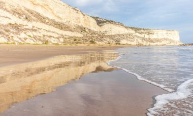Kıbrıs 'ın kumlu sahillerinde dalgalar, güzel yaz deniz manzarası, deniz köpüğü ve kaya.