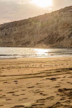 KKKTC sahilinde sıcak gün batımı, denizin üstünde kaya, atmosferik arazi manzarası