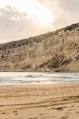 KKKTC sahilinde sıcak gün batımı, denizin üstünde kaya, atmosferik arazi manzarası