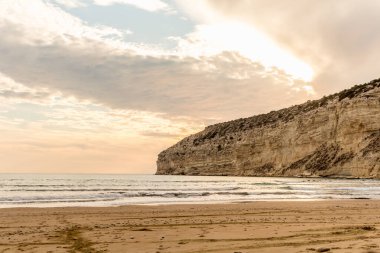 KKKTC sahilinde sıcak gün batımı, denizin üstünde kaya, atmosferik arazi manzarası