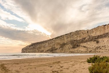 KKKTC sahilinde sıcak gün batımı, denizin üstünde kaya, atmosferik arazi manzarası