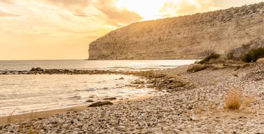 KKKTC sahilinde sıcak gün batımı, denizin üstünde kaya, atmosferik arazi manzarası