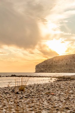 KKKTC sahilinde sıcak gün batımı, denizin üstünde kaya, atmosferik arazi manzarası