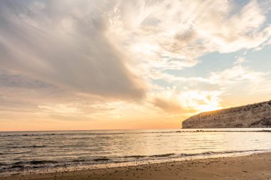 KKKTC sahilinde sıcak gün batımı, denizin üstünde kaya, atmosferik arazi manzarası