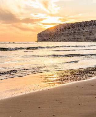 KKKTC sahilinde sıcak gün batımı, denizin üstünde kaya, atmosferik arazi manzarası