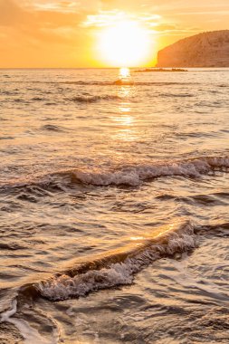 KKKTC sahilinde sıcak gün batımı, denizin üstünde kaya, atmosferik arazi manzarası