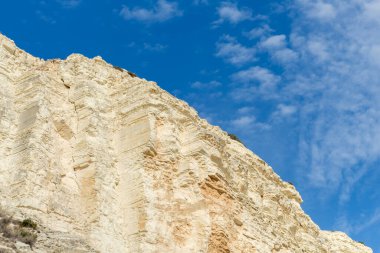 Altın uçurumlar, huzurlu bir mavi gökyüzüne karşı yükseliyor. Huzurlu bir izolasyon ve doğal güzellik hissi uyandırıyor. Seyahat broşürleri ya da çevresel farkındalık kampanyaları için mükemmel.