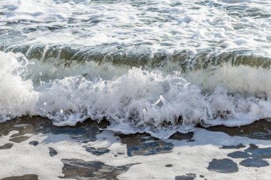 Kıbrıs 'ın kumlu sahillerinde dalgalar, güzel yaz deniz manzarası, deniz köpüğü ve kaya.