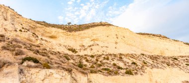 Altın uçurumlar, huzurlu bir mavi gökyüzüne karşı yükseliyor. Huzurlu bir izolasyon ve doğal güzellik hissi uyandırıyor. Seyahat broşürleri ya da çevresel farkındalık kampanyaları için mükemmel.
