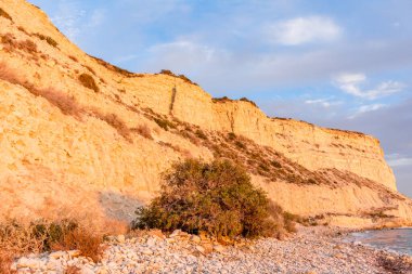 Altın uçurumlar, huzurlu bir mavi gökyüzüne karşı yükseliyor. Huzurlu bir izolasyon ve doğal güzellik hissi uyandırıyor. Seyahat broşürleri ya da çevresel farkındalık kampanyaları için mükemmel.
