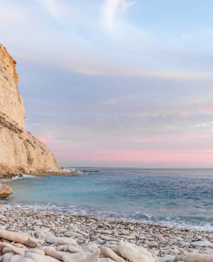 Dramatik uçurumlar, alacakaranlıkta yumuşak dalgalarla karşılaşır. Yalnız bir kaya bekçisi, dayanıklılık, yalnızlık ve doğal güzellik temalarını iletmek için idealdir.