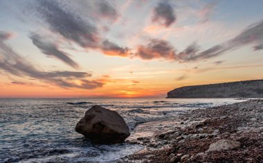 Dramatik uçurumlar, alacakaranlıkta yumuşak dalgalarla karşılaşır. Yalnız bir kaya bekçisi, dayanıklılık, yalnızlık ve doğal güzellik temalarını iletmek için idealdir.
