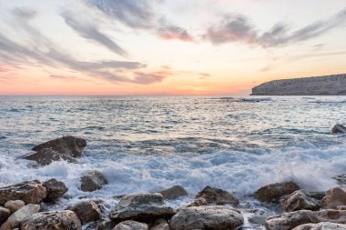 Dramatik uçurumlar, alacakaranlıkta yumuşak dalgalarla karşılaşır. Yalnız bir kaya bekçisi, dayanıklılık, yalnızlık ve doğal güzellik temalarını iletmek için idealdir.