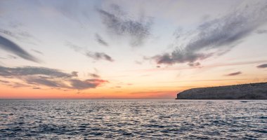 Dramatik uçurumlar, alacakaranlıkta yumuşak dalgalarla karşılaşır. Yalnız bir kaya bekçisi, dayanıklılık, yalnızlık ve doğal güzellik temalarını iletmek için idealdir.