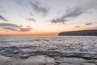 Dramatik uçurumlar, alacakaranlıkta yumuşak dalgalarla karşılaşır. Yalnız bir kaya bekçisi, dayanıklılık, yalnızlık ve doğal güzellik temalarını iletmek için idealdir.