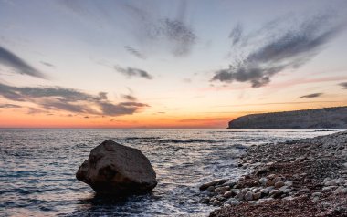 Dramatik uçurumlar, alacakaranlıkta yumuşak dalgalarla karşılaşır. Yalnız bir kaya bekçisi, dayanıklılık, yalnızlık ve doğal güzellik temalarını iletmek için idealdir.