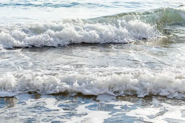 Kıbrıs 'ın kumlu sahillerinde dalgalar, güzel yaz deniz manzarası, deniz köpüğü ve kaya.