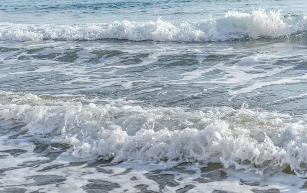 Kıbrıs 'ın kumlu sahillerinde dalgalar, güzel yaz deniz manzarası, deniz köpüğü ve kaya.