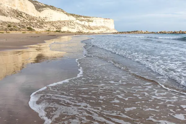 Kıbrıs 'ın kumlu sahillerinde dalgalar, güzel yaz deniz manzarası, deniz köpüğü ve kaya.