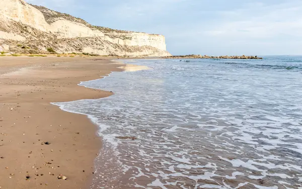 Kıbrıs 'ın kumlu sahillerinde dalgalar, güzel yaz deniz manzarası, deniz köpüğü ve kaya.