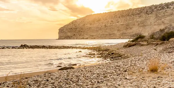 KKKTC sahilinde sıcak gün batımı, denizin üstünde kaya, atmosferik arazi manzarası