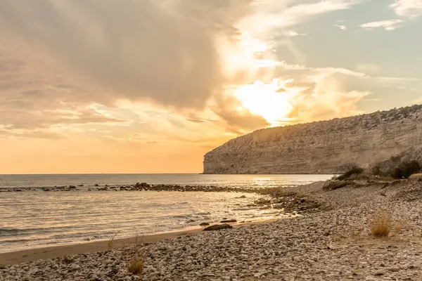 KKKTC sahilinde sıcak gün batımı, denizin üstünde kaya, atmosferik arazi manzarası