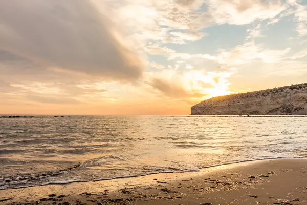 KKKTC sahilinde sıcak gün batımı, denizin üstünde kaya, atmosferik arazi manzarası