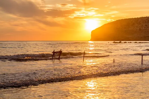 KKKTC sahilinde sıcak gün batımı, denizin üstünde kaya, atmosferik arazi manzarası