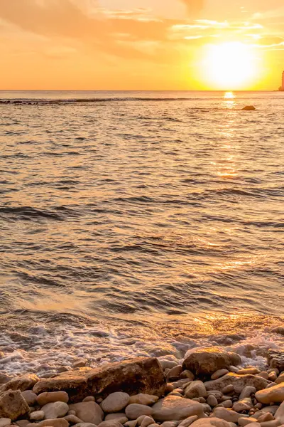 KKKTC sahilinde sıcak gün batımı, denizin üstünde kaya, atmosferik arazi manzarası