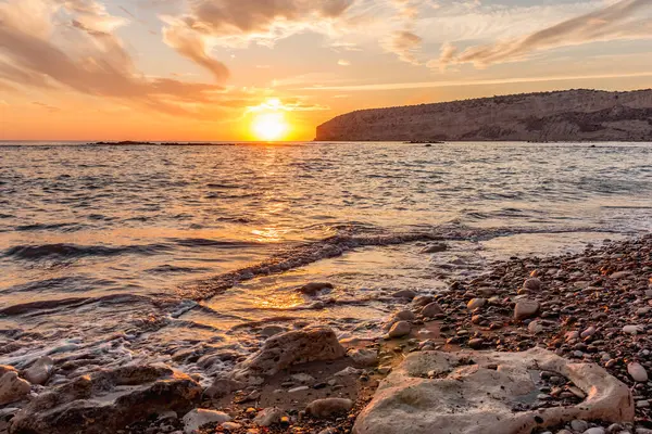 KKKTC sahilinde sıcak gün batımı, denizin üstünde kaya, atmosferik arazi manzarası