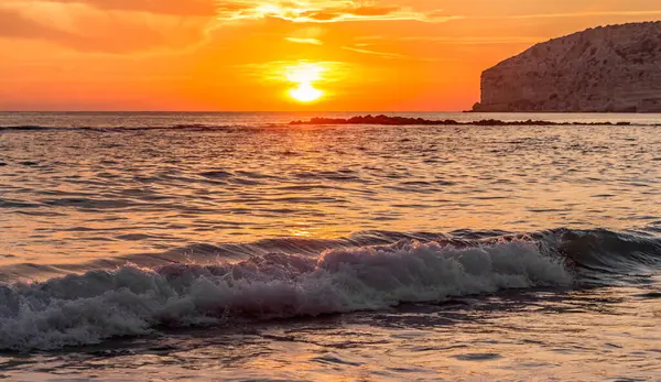 KKKTC sahilinde sıcak gün batımı, denizin üstünde kaya, atmosferik arazi manzarası
