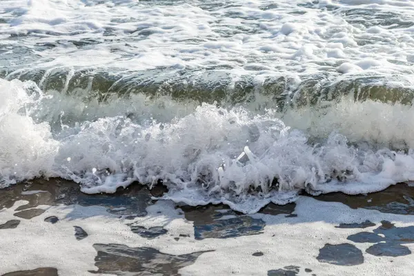 Kıbrıs 'ın kumlu sahillerinde dalgalar, güzel yaz deniz manzarası, deniz köpüğü ve kaya.