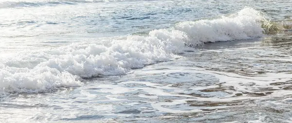 Kıbrıs 'ın kumlu sahillerinde dalgalar, güzel yaz deniz manzarası, deniz köpüğü ve kaya.