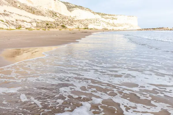 Kıbrıs 'ın kumlu sahillerinde dalgalar, güzel yaz deniz manzarası, deniz köpüğü ve kaya.