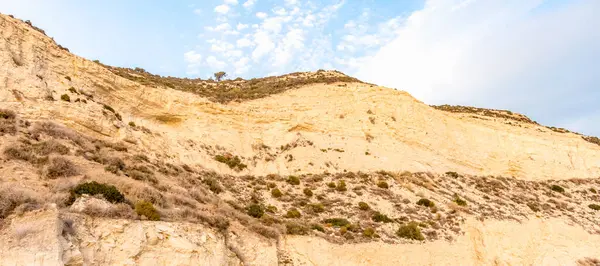 Altın uçurumlar, huzurlu bir mavi gökyüzüne karşı yükseliyor. Huzurlu bir izolasyon ve doğal güzellik hissi uyandırıyor. Seyahat broşürleri ya da çevresel farkındalık kampanyaları için mükemmel.