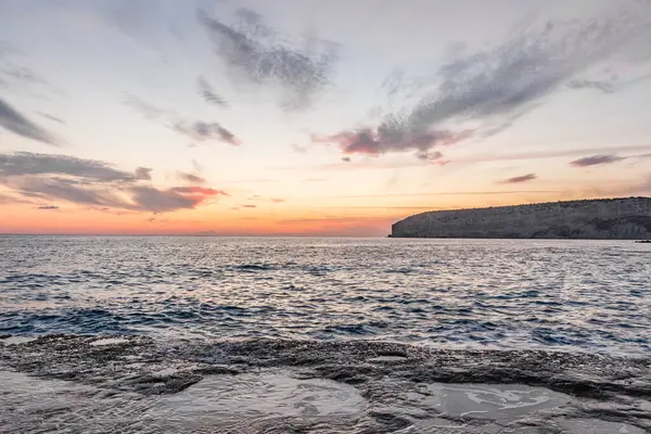 Dramatik uçurumlar, alacakaranlıkta yumuşak dalgalarla karşılaşır. Yalnız bir kaya bekçisi, dayanıklılık, yalnızlık ve doğal güzellik temalarını iletmek için idealdir.