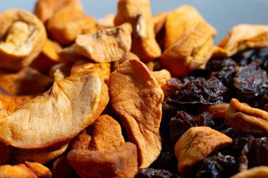 Bir kasede kurumuş elma ve erik.